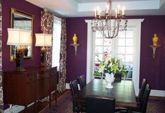 a dining room with purple walls and chandelier