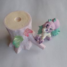 a roll of toilet paper next to a toy pony