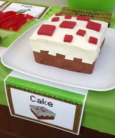 there is a cake on the table with red and white frosting in front of it