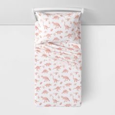 an image of a bed with pink dinosaurs on it