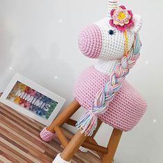 a crocheted unicorn sitting on top of a wooden chair