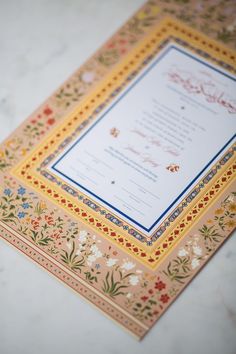 an ornate wedding card on a marble table