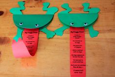 two paper frog puppets on a wooden table