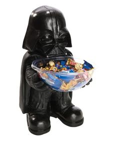 a darth vader bowl filled with cereal in it's hands and sitting on the ground