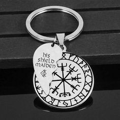 a metal keychain with a compass on it sitting on top of a bench