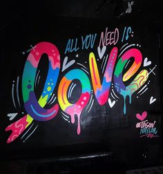 the word love painted on the side of a building with spray paint all over it