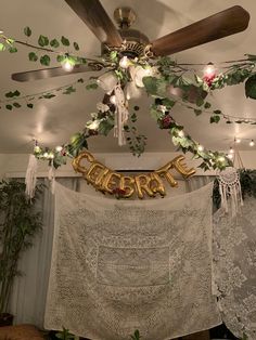 the ceiling fan is decorated with greenery and gold letters that spell out'cheers '