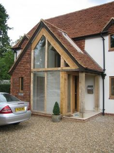 a car is parked in front of a house that has been built into the side of it