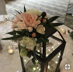 a vase filled with flowers sitting on top of a white table cloth covered dining room