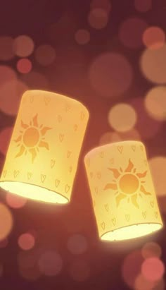 two yellow lamps sitting next to each other on top of a table with lights in the background