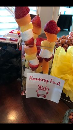 some strawberries and other fruits are on sticks