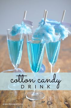 three glasses filled with cotton candy drink on top of a wooden table