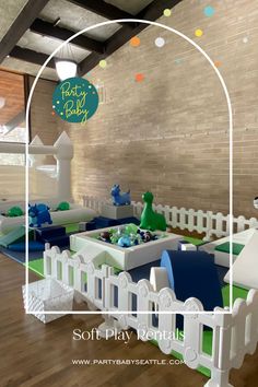 an indoor play area with white picket fence and blue and green toys on the floor