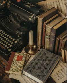 an old fashioned typewriter, books and candles on a table