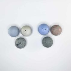 four different colored balls on a white surface with one in the middle and one in the center