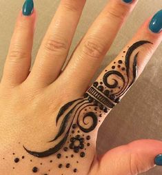 a woman's hand with a black and white tattoo design on the middle finger