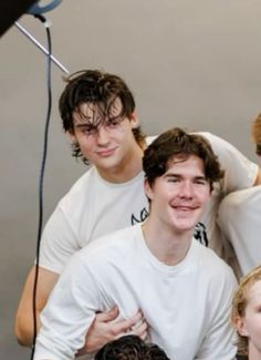 a group of young men standing next to each other in front of a camera set