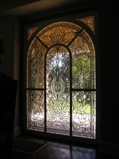 an ornate stained glass window in a dark room