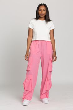 NEW Limited Edition & custom designed Pink Parachute Pants! Not only did we spend months designing these amazing cargo style pants, but we PERFECTED them in the process! These pants are insanely versatile due to their lightweight material and trendy style. They feature adjustable ankle cuffs that you can leave wide or tie up for a jogger look. The elastic waist-band allows for a comfortable fit and the multiple pockets provide great functionality. These pants easily can be worn for any workout o Pink Utility Cargo Pants, Pink Utility Cargo Pants With Pockets, Baggy Pink Cargo Pants With Cargo Pockets, Pink Straight Cargo Pants, Summer Pink Parachute Pants With Cargo Pockets, Pink Cargo Style Parachute Pants, Trendy Summer Nylon Cargo Pants, Fitted Parachute Pants With Multiple Pockets For Spring, Trendy Nylon Cargo Pants For Summer