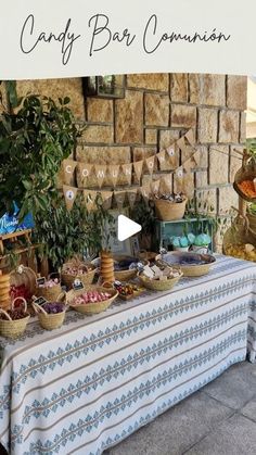 a table with food on it in front of a brick wall and banner that says candy bar commission