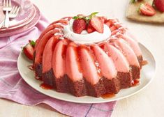 a bundt cake with strawberries and whipped cream on top