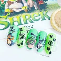 the nail polish is green with cartoon characters on it, along with a sticker that says shrek you