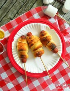 some food is on a paper plate with toothpicks and sauces next to it