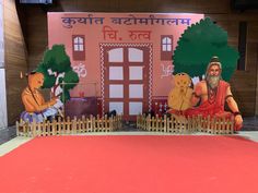 an outdoor stage set up with people sitting on the ground and one man standing in front of it