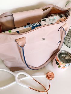 a pink purse sitting on top of a white table next to scissors and other items