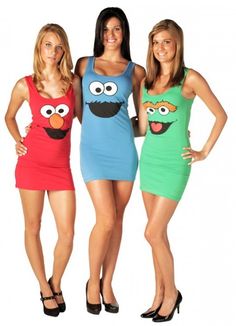 three women in sesame characters costumes posing for the camera with their hands on their hipss