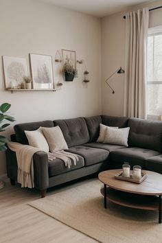 a living room with a couch, coffee table and two pictures on the wall above it