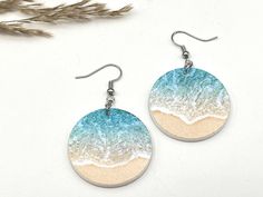 "Beach Themed Earrings These beautiful clear acrylic beach-inspired earrings are perfect for summer. Grab a pair or two for that beach or cruise vacation. Excellent gift idea!  * These earrings are made of printed Acrylic. Acrylic gives that minimalist feel, is lightweight, and comes with a bright vibrant print.  * The beachy design is printed on both sides * The earrings are 2 long, 1\" wide, and 1/8\" thick  * Hardware comes in either silver or gold plated. * Includes fishhook with rubber earring stoppers * All of our items are handcrafted in Topsail Nc We offer free shipping on all orders over $35! Follow our shop to get notifications of new designs and Sales!!  Looking for customized earrings for a special occasion or holiday, feel free to contact us.A" White Resin Earrings For Summer, Summer Vacation Drop Earrings, Round Beach Earrings For Summer, Summer Beach Drop Earrings, Round Summer Beach Earrings, Handmade Earrings For Summer Vacation, Sand Colored Beach Jewelry For Beach Season, Round Summer Vacation Earrings, Sand-colored Beach Jewelry