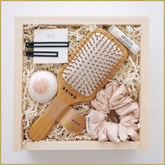 a wooden box containing a brush, hairdryer and other items