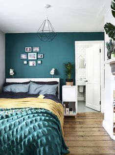 a bed room with a neatly made bed and green walls