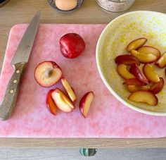 apples are cut up in half on a cutting board next to a knife and bowl