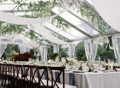 the tables are set with white flowers and greenery