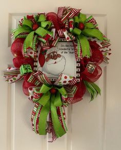 a christmas wreath hanging on a door with the words merry christmas and santa claus's face