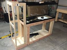 a large fish tank sitting on top of a wooden shelf in a room filled with tools