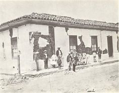 an old black and white photo of people standing in front of a building