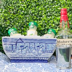 a blue and white bowl sitting on top of a table next to bottles of liquor