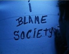 a sign that says i blame society in black ink on a blue background