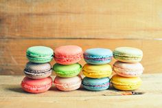 a stack of macaroons sitting on top of a wooden table next to each other