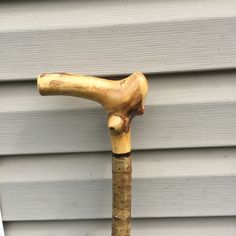 an old wooden walking stick leaning against a house