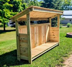 a wooden outhouse sitting on top of a lush green field