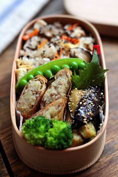 a bento box filled with different types of food on top of a wooden table