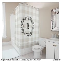 a bathroom with a checkered shower curtain and monogrammed wreath on the shower curtain