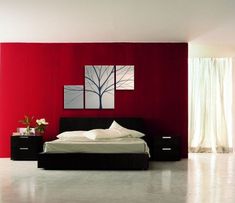 a bedroom with red walls and black furniture