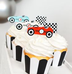 three cupcakes with white frosting and race cars on them