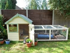 a small white chicken coop in the backyard