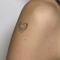 a woman with a heart tattoo on her left shoulder and right arm behind her back